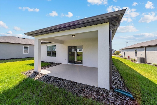 rear view of house featuring a yard, a patio, and central air condition unit