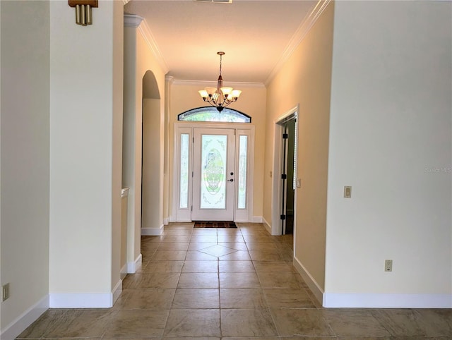 entryway with ornamental molding and a notable chandelier