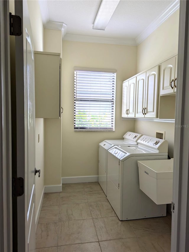 laundry room featuring cabinets, ornamental molding, washer and clothes dryer, and sink