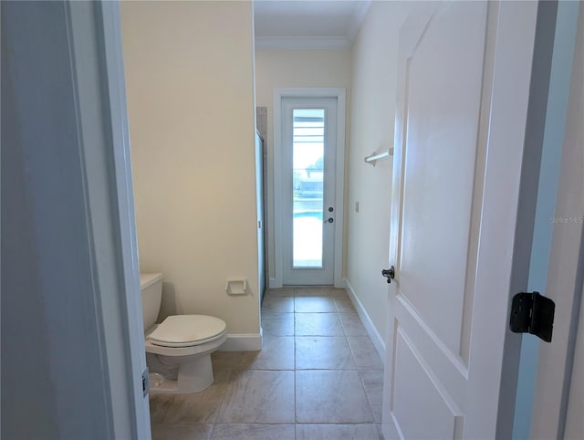 bathroom with crown molding, toilet, and tile patterned flooring