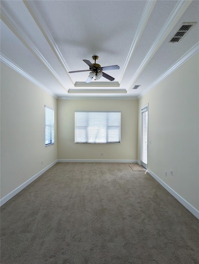 carpeted empty room with ornamental molding, a tray ceiling, ceiling fan, and a textured ceiling