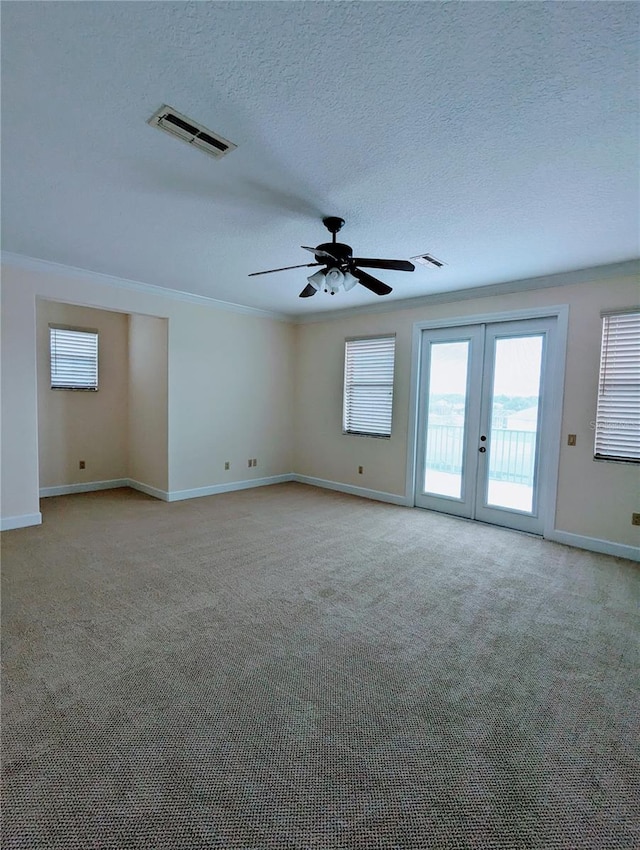 carpeted empty room with french doors, a textured ceiling, ornamental molding, and ceiling fan