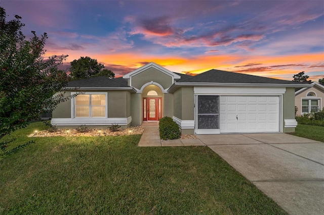 ranch-style home with a yard, driveway, an attached garage, and stucco siding