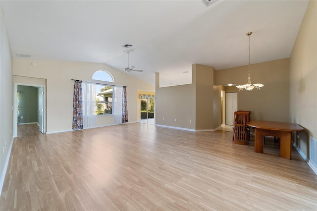 unfurnished living room with light wood-type flooring, ceiling fan with notable chandelier, and vaulted ceiling