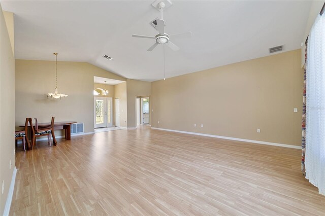 living room with ceiling fan with notable chandelier, lofted ceiling, and light hardwood / wood-style floors