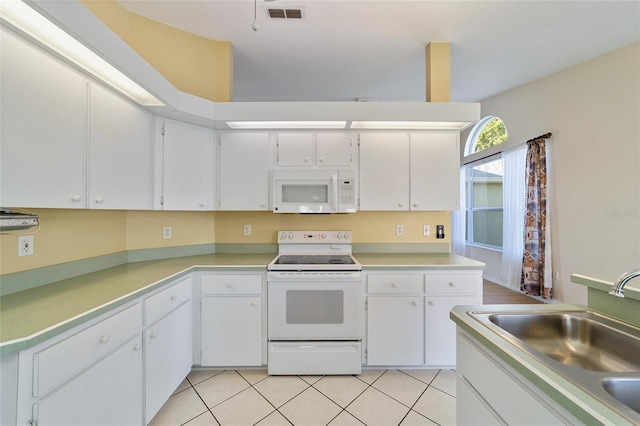 kitchen with white appliances, white cabinetry, sink, and light tile patterned flooring