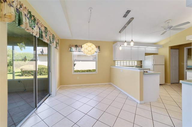 kitchen with white cabinetry, kitchen peninsula, light tile patterned floors, pendant lighting, and ceiling fan