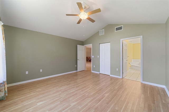 unfurnished bedroom featuring connected bathroom, a closet, light wood-type flooring, lofted ceiling, and ceiling fan