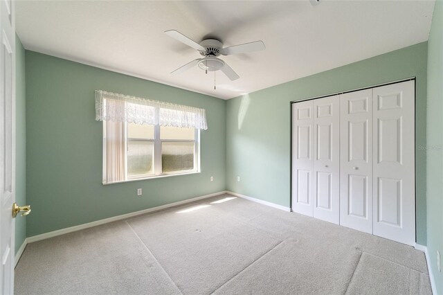 unfurnished bedroom featuring ceiling fan, a closet, and carpet