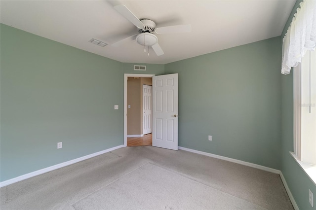 empty room with ceiling fan and light colored carpet