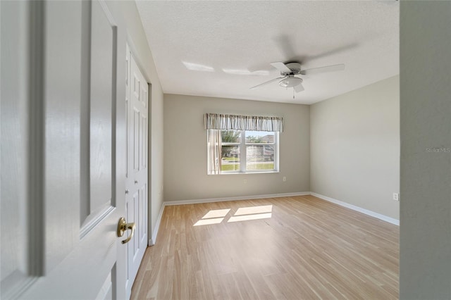 unfurnished bedroom featuring a textured ceiling, ceiling fan, and light hardwood / wood-style flooring