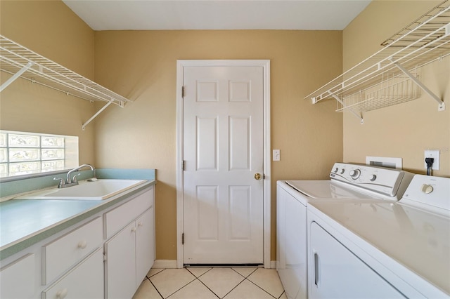 laundry room featuring separate washer and dryer, sink, light tile patterned floors, and cabinets