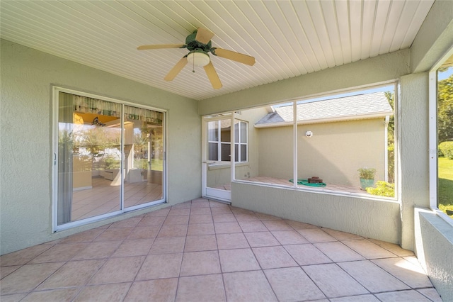 unfurnished sunroom with ceiling fan and a wealth of natural light