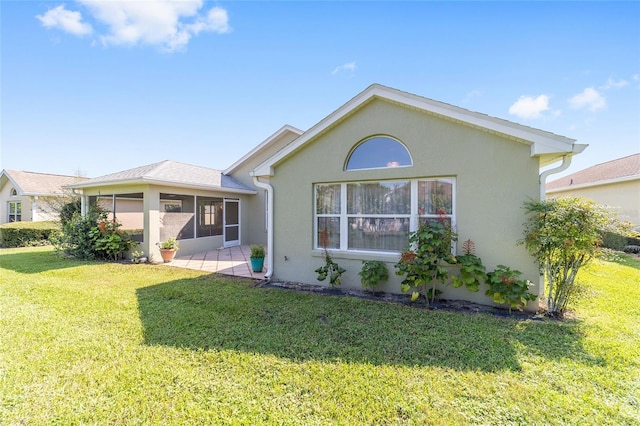 back of house featuring a sunroom and a yard