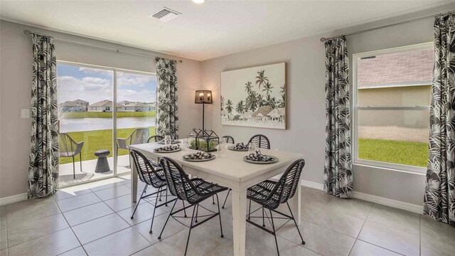 tiled dining area with a water view and plenty of natural light