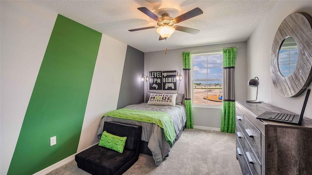 bedroom featuring ceiling fan, light colored carpet, and a textured ceiling