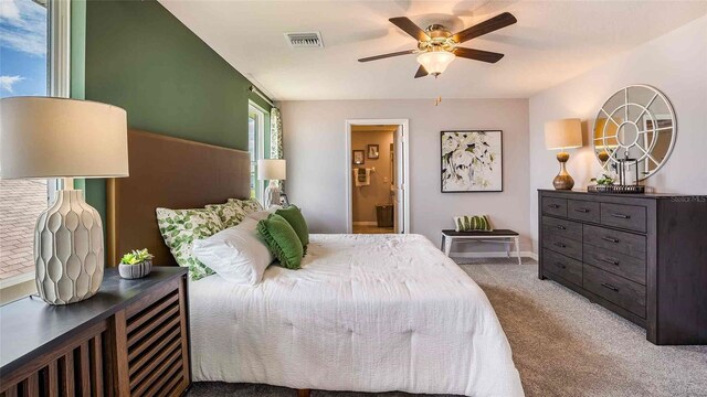 bedroom featuring ceiling fan, connected bathroom, and light carpet