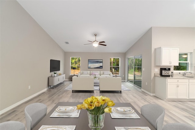 living room with vaulted ceiling, sink, light hardwood / wood-style flooring, and ceiling fan