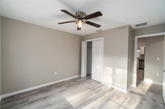 unfurnished bedroom featuring light hardwood / wood-style floors, ceiling fan, and a closet