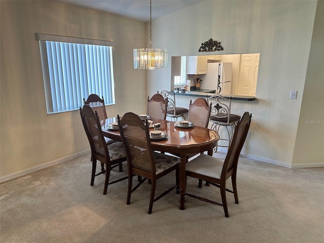 carpeted dining area with a chandelier