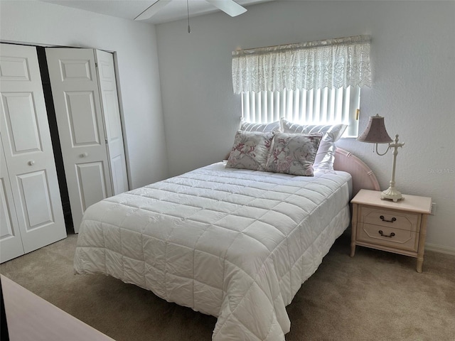 bedroom with ceiling fan, light colored carpet, and multiple closets