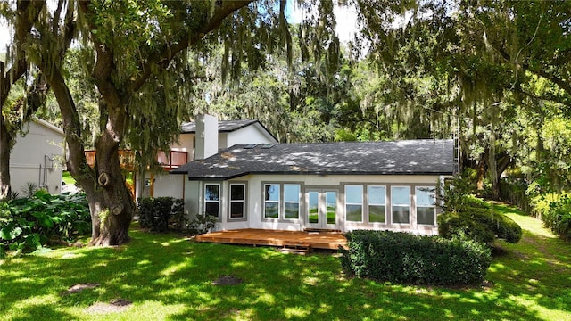 rear view of property with a deck and a yard