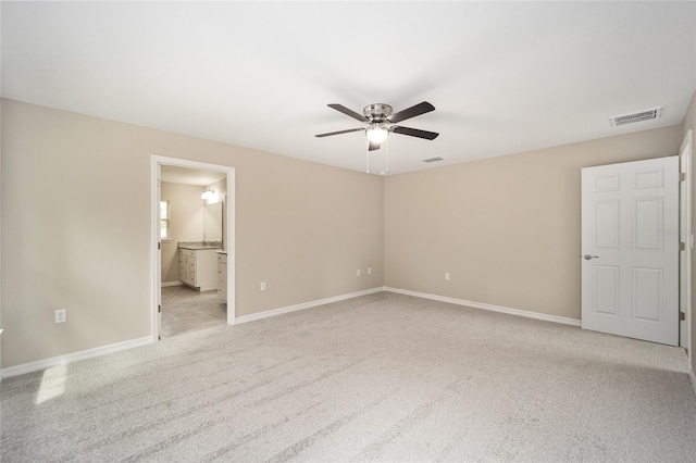 unfurnished bedroom with ensuite bathroom, ceiling fan, and light colored carpet