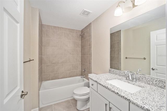 full bathroom with a textured ceiling, vanity, tile patterned floors, toilet, and tiled shower / bath combo