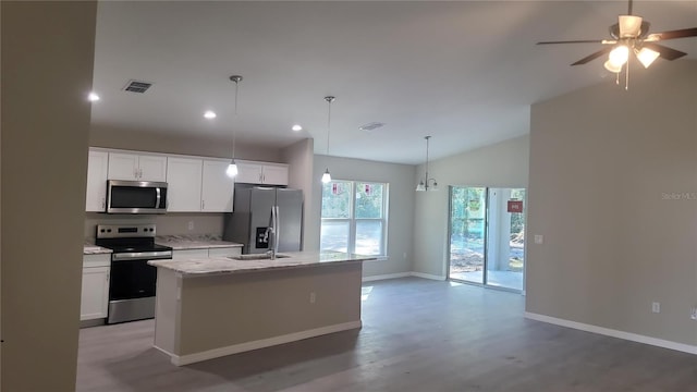 kitchen featuring white cabinets, hardwood / wood-style floors, appliances with stainless steel finishes, and an island with sink