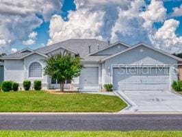 ranch-style home with a garage and a front lawn