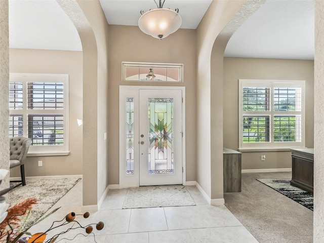 foyer entrance featuring light tile patterned flooring and plenty of natural light