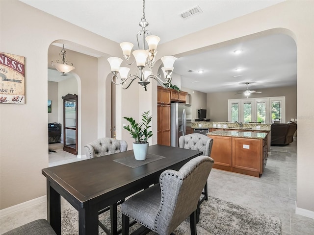 tiled dining space with ceiling fan with notable chandelier