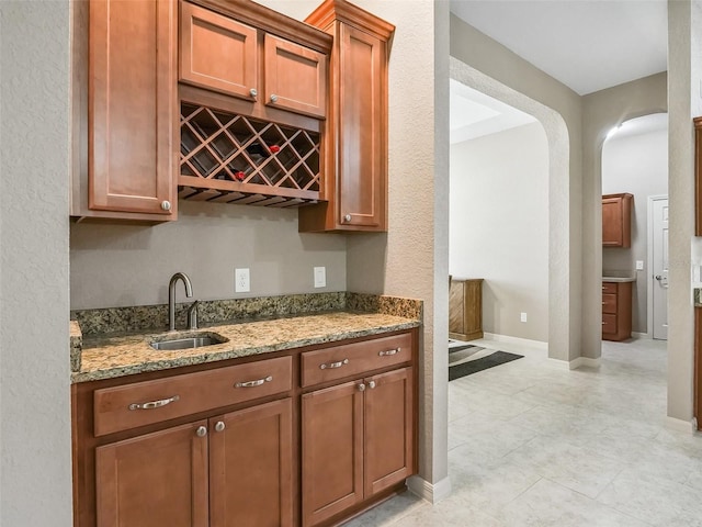 kitchen featuring light stone counters and sink