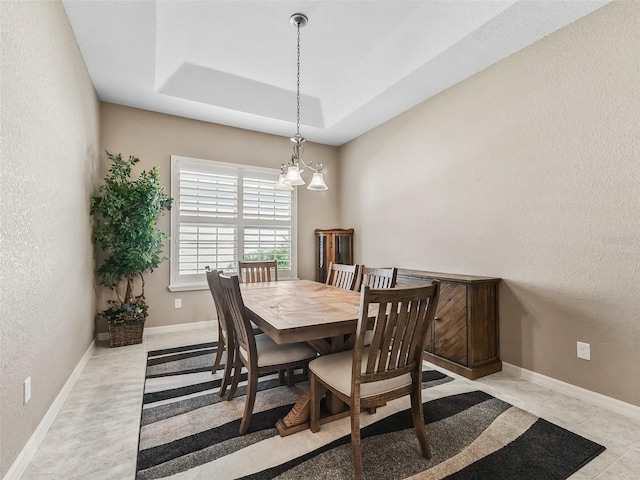 dining area with a raised ceiling