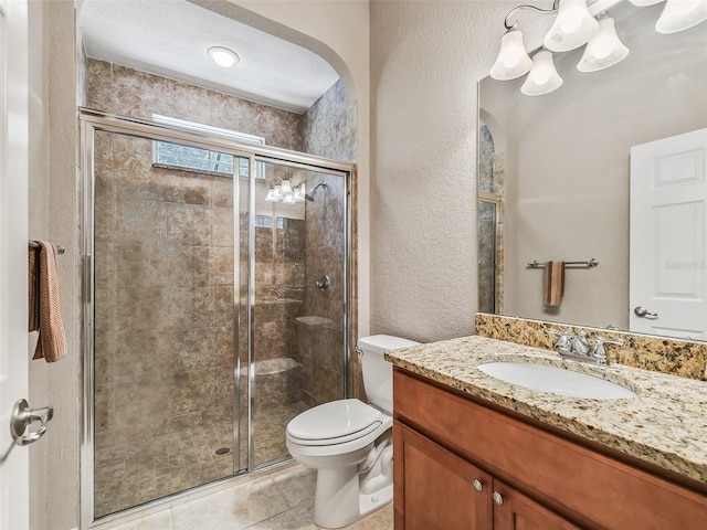 bathroom featuring an enclosed shower, vanity, tile patterned floors, and toilet