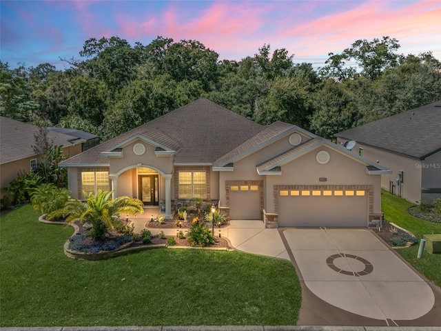 view of front of home featuring a garage and a yard