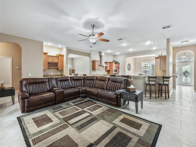 tiled living room with ceiling fan