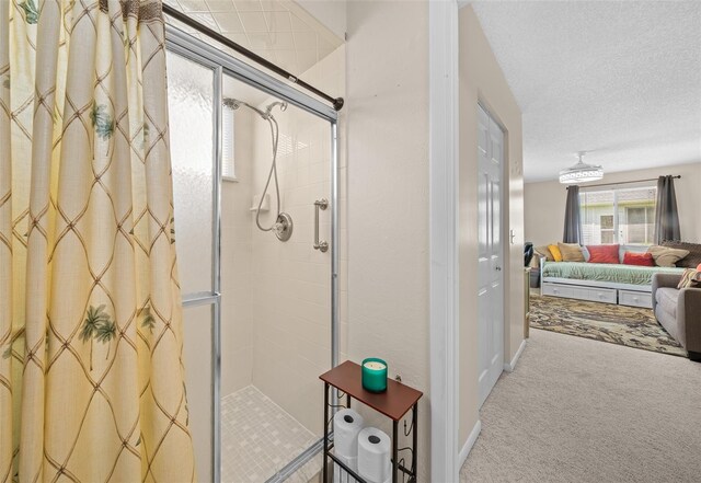 bathroom featuring ensuite bathroom, a textured ceiling, and a shower stall