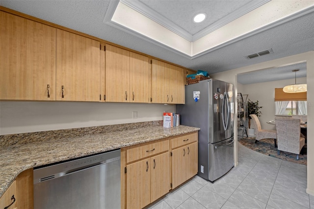 kitchen with light brown cabinets, a textured ceiling, decorative light fixtures, light stone counters, and stainless steel appliances