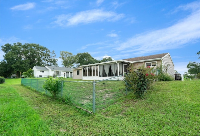 back of house with a sunroom and a yard