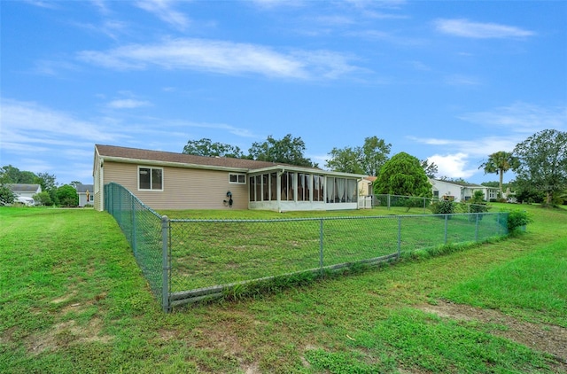 rear view of property with a sunroom and a lawn