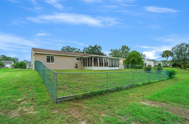 back of property featuring a sunroom, a fenced backyard, and a lawn