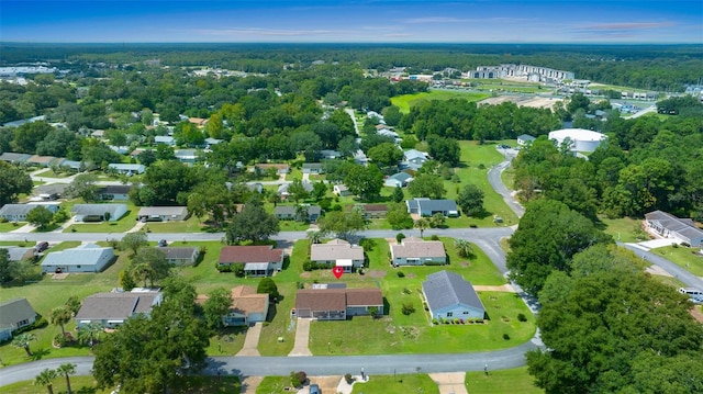 drone / aerial view with a wooded view and a residential view