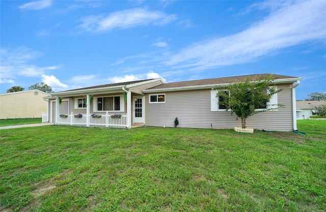rear view of house featuring a yard and covered porch