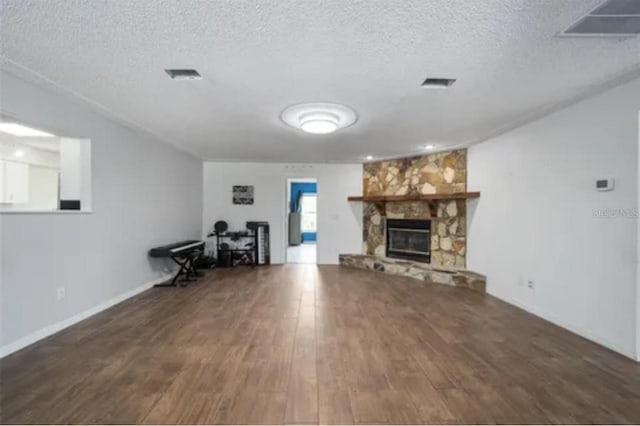 unfurnished living room with a textured ceiling, a fireplace, and dark wood-type flooring