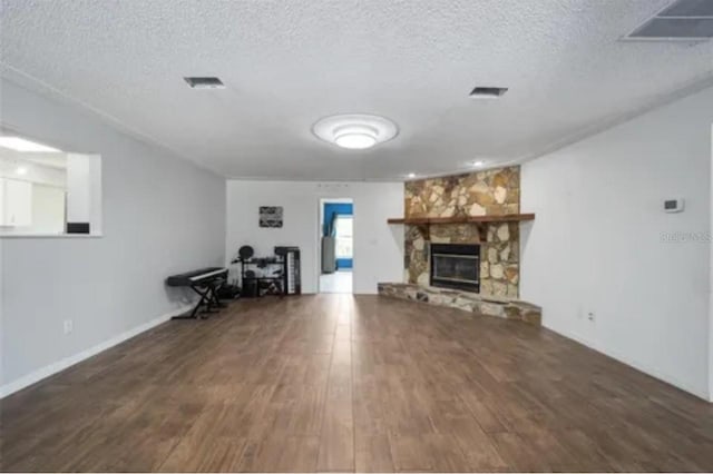 15735 SW 52nd Avenue Rd, Ocala, FL 34473 - unfurnished living room featuring a stone fireplace, visible vents, wood finished floors, and a textured ceiling