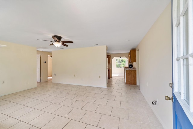 tiled spare room featuring ceiling fan