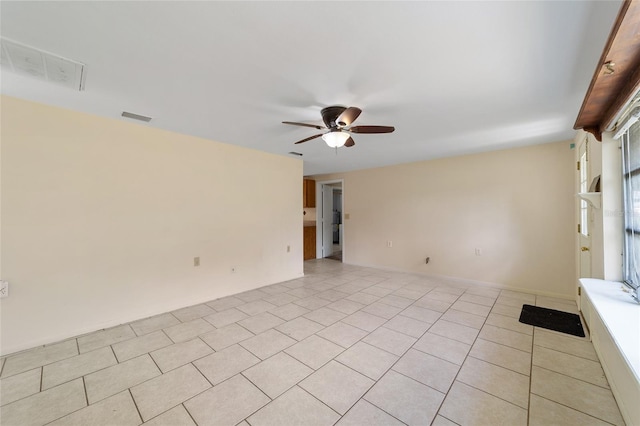 tiled spare room featuring ceiling fan