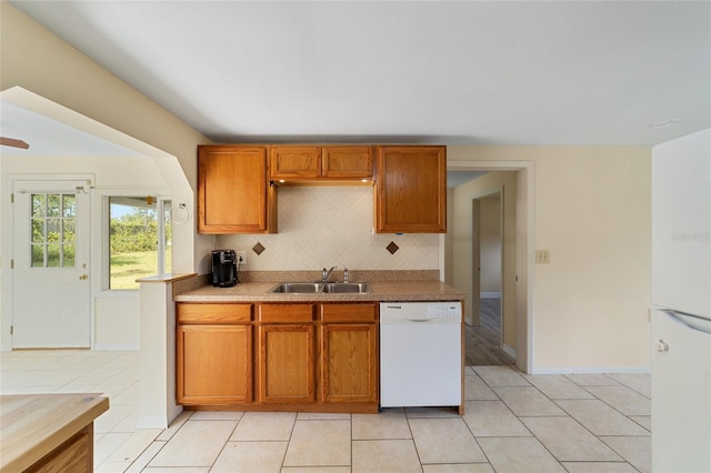 kitchen with light tile patterned floors, dishwasher, backsplash, and sink