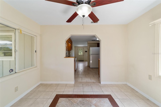 tiled spare room with ceiling fan